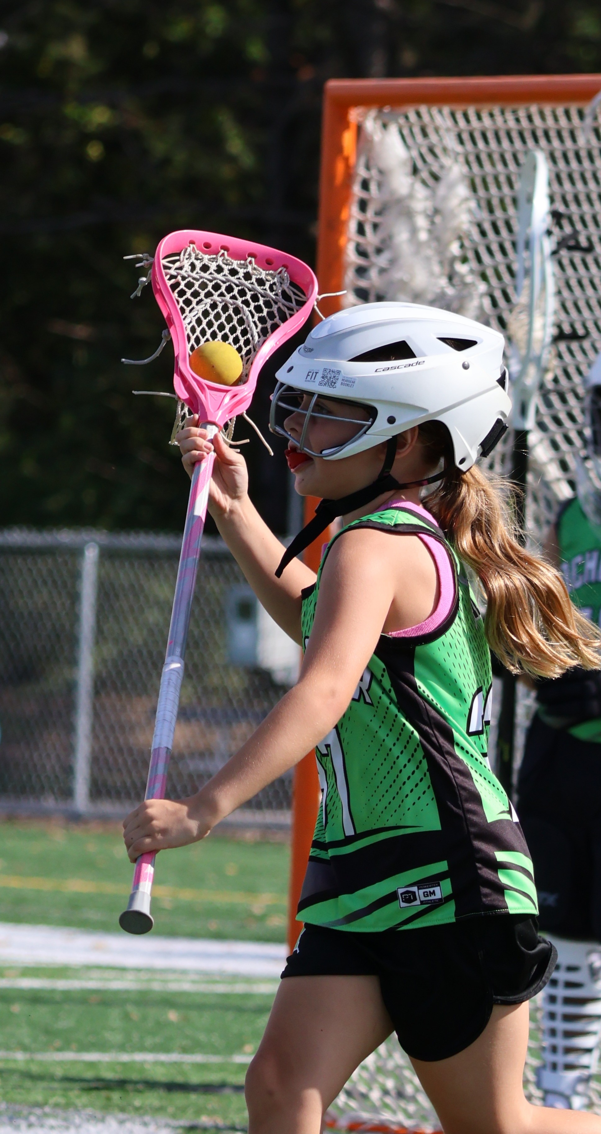 Young girl playing lacrosse.