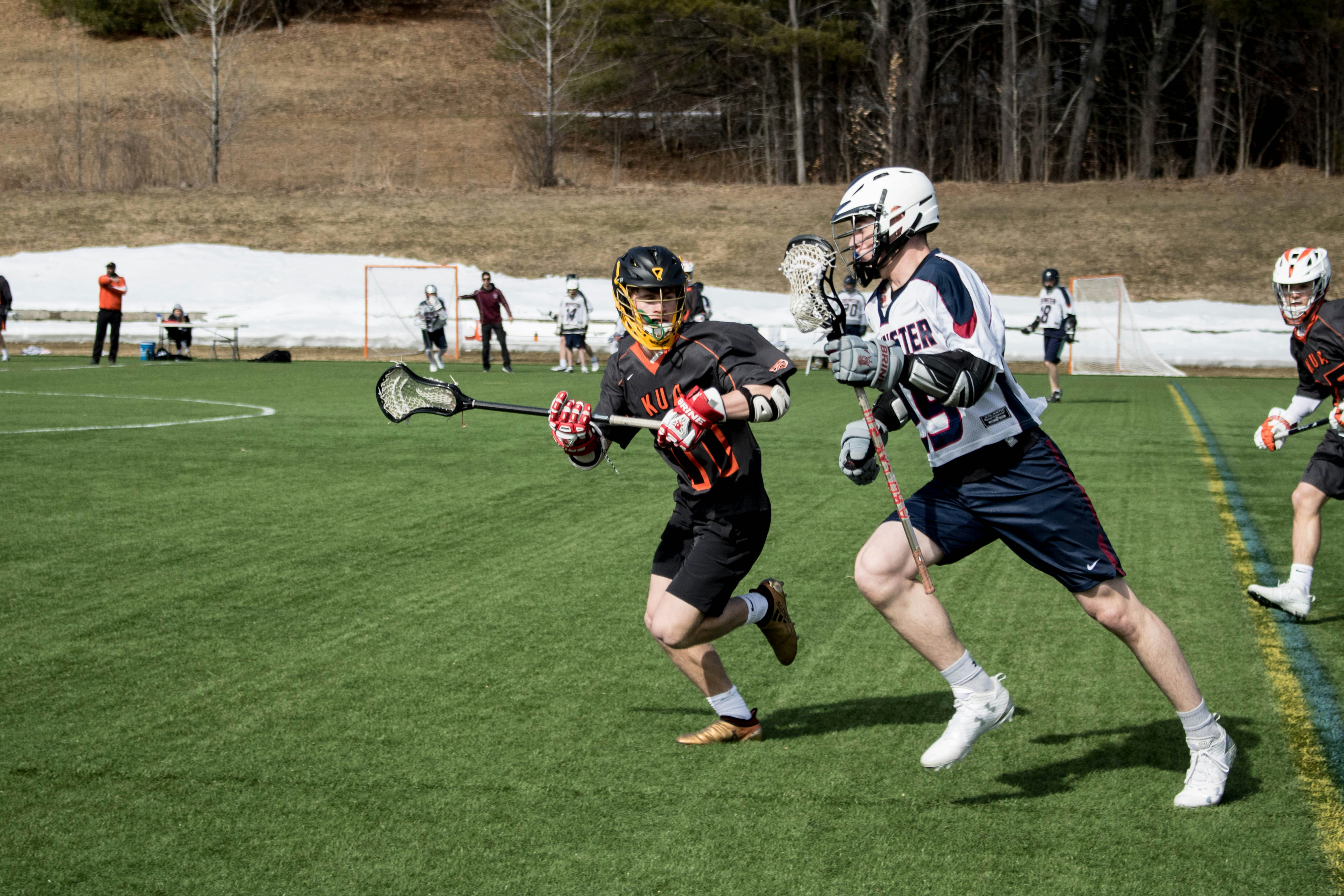 Offensive lacrosse player with the ball working on defender in the offensive zone.